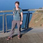 Eine Frau steht auf einer Aussichtsplattform. Im Hintergrund ist das Meer zu sehen.